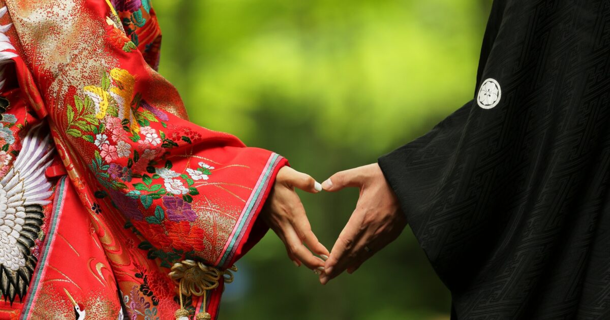 和装の男女が手でハートを作る結婚式の演出