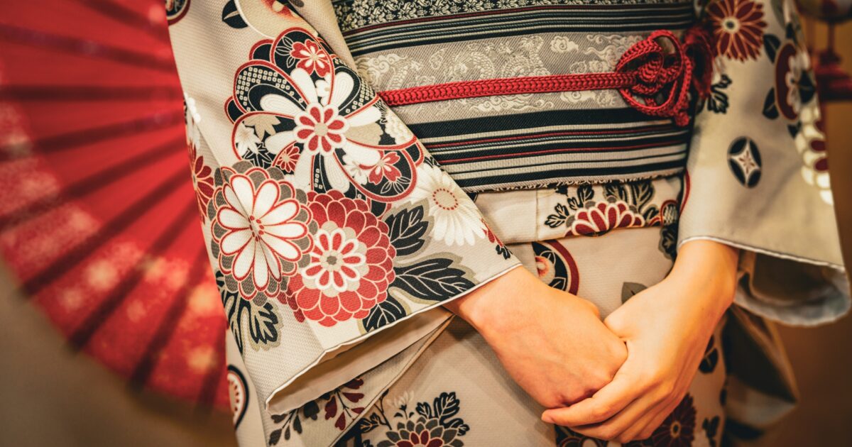 赤と黒の花柄が入った着物と帯のアップ