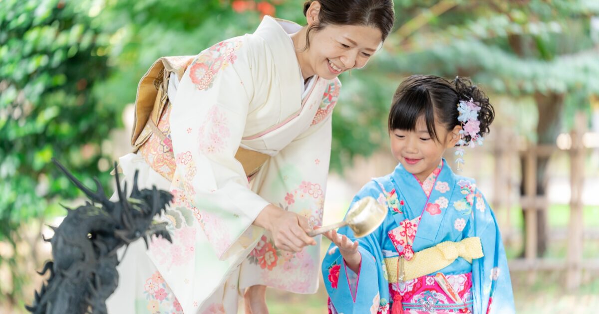 神社の手水舎で手を清める着物姿の母娘