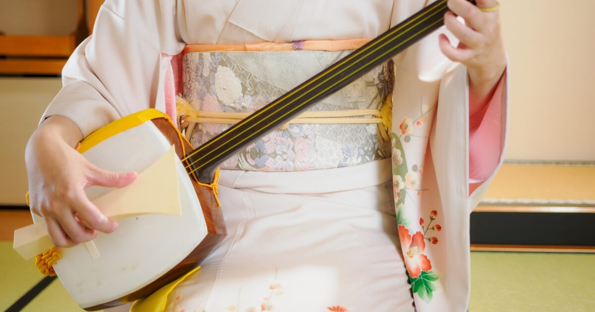 和装の女性が三味線を演奏している様子
