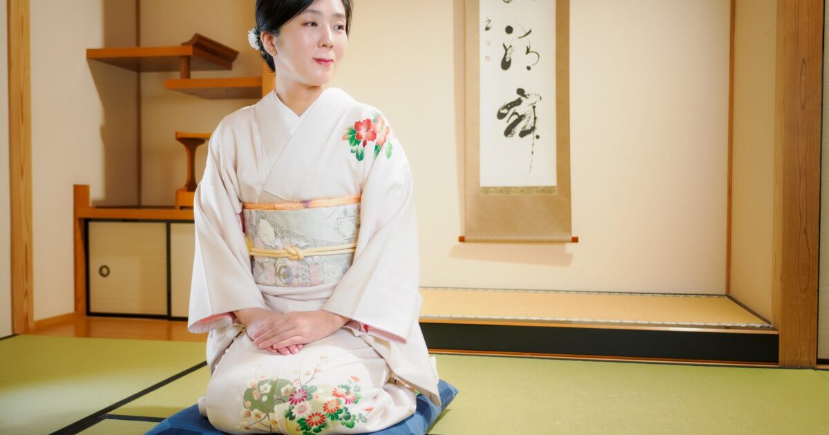和室の床の間で正座する訪問着姿の女性