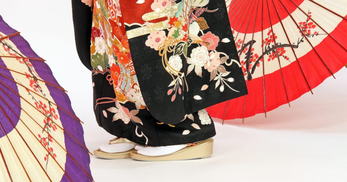 黒地に色鮮やかな花柄が描かれた振袖と草履の足元