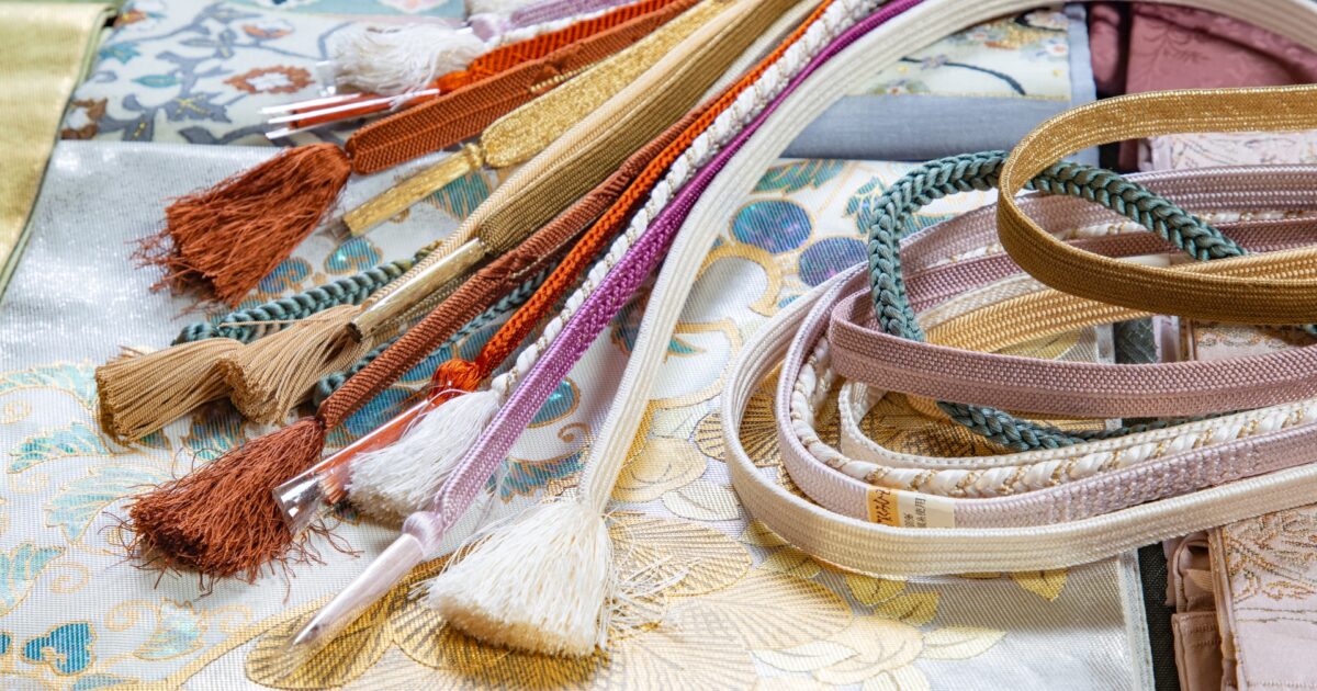 色とりどりの帯締めと帯揚げが並ぶ和装小物のアップ