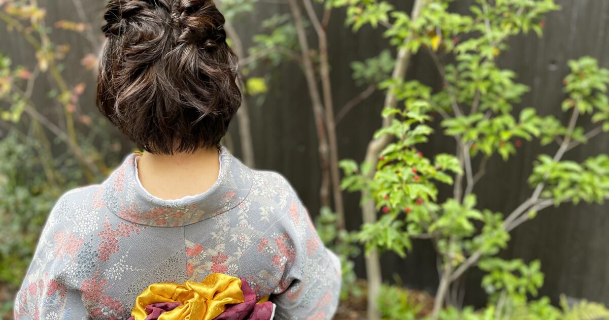 華やかな帯を締めた着物姿の女性の後ろ姿